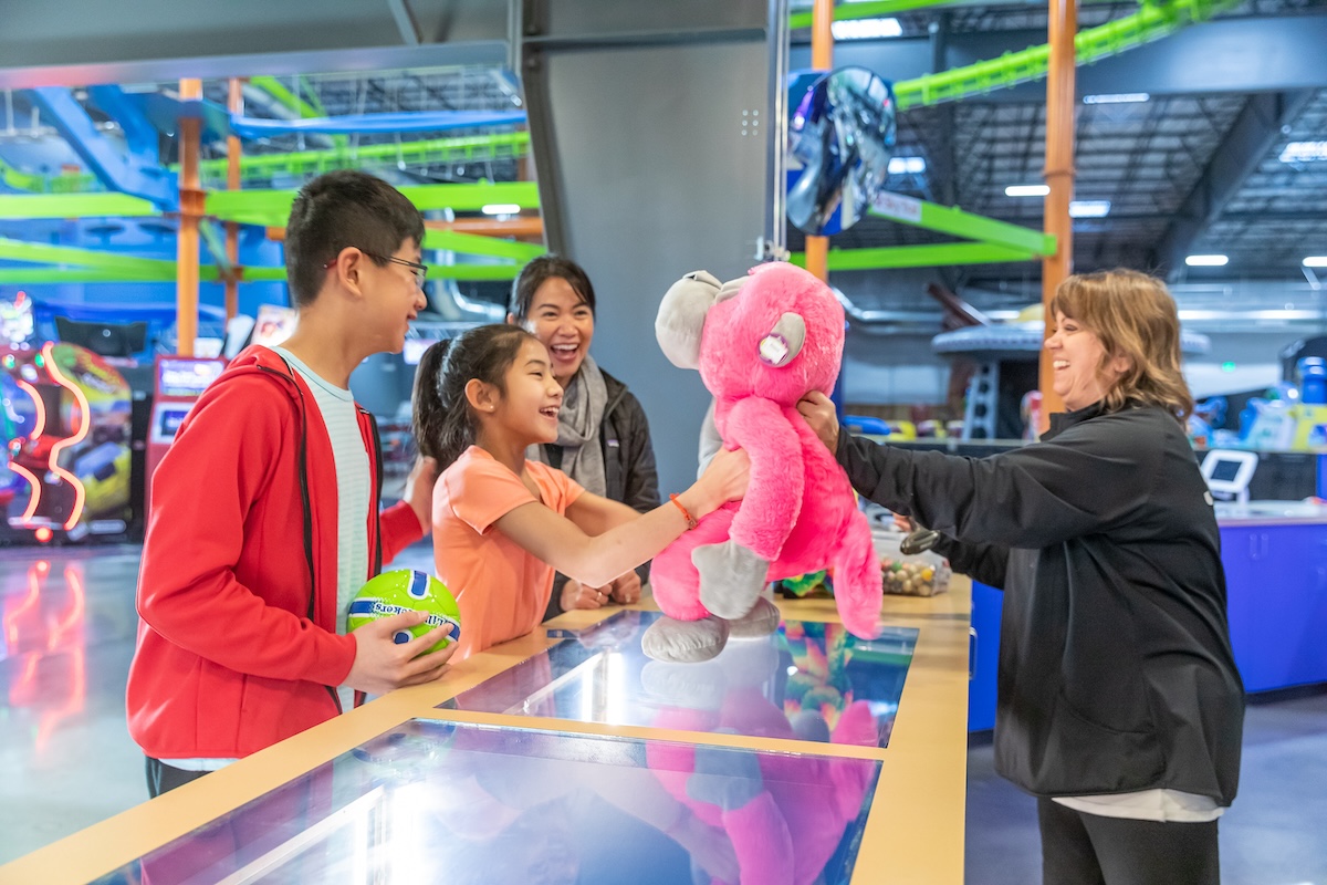 family with girl receiving pink plush toy